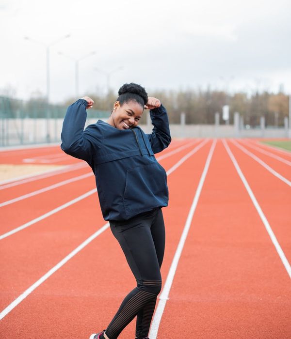 Woman in activewear performing a light cardio exercise in a modern room.